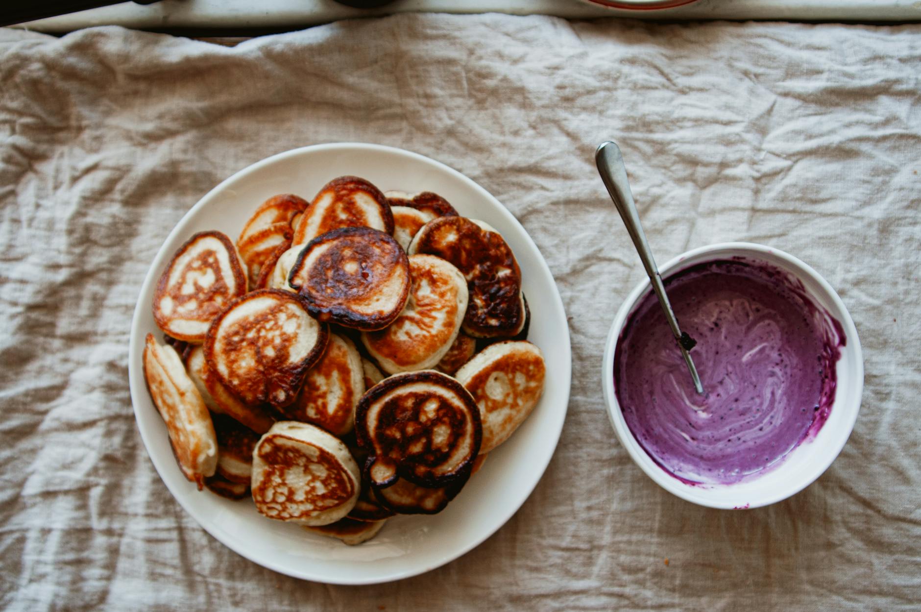 Naleśniki na talerzu z sosem jagodowym w rustykalnej aranżacji