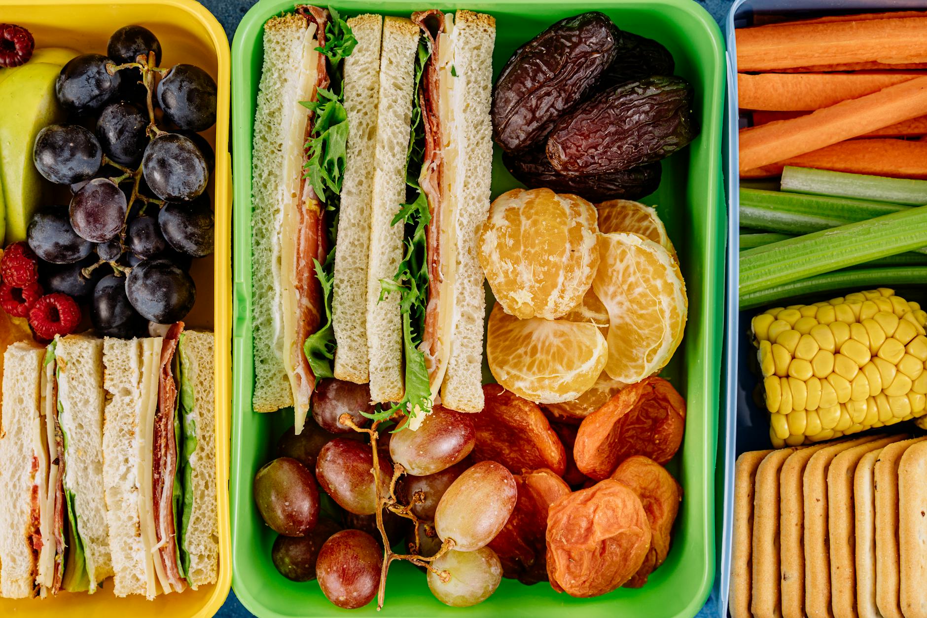 Kolorowy lunchbox dla dziecka z kanapkami, owocami i warzywami